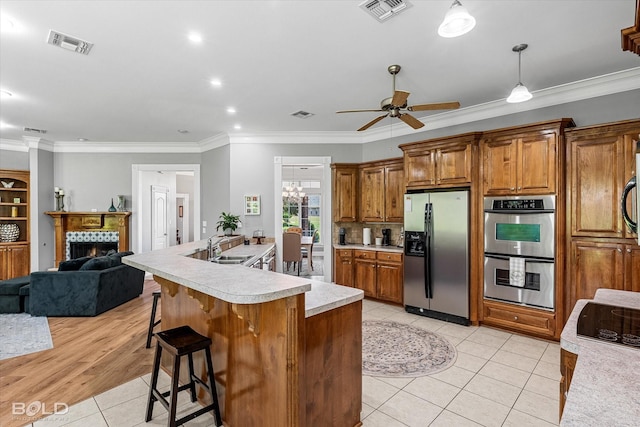 309 Slate Cir, Haughton, LA 71037 - kitchen with stainless steel appliances, light tile patterned flooring, light countertops, brown cabinets, and a sink