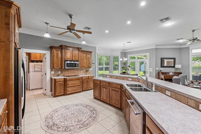 309 Slate Cir, Haughton, LA 71037 - kitchen featuring stainless steel appliances, a ceiling fan, a sink, brown cabinetry, and ornamental molding