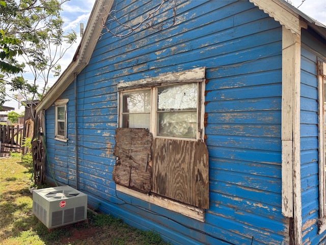 view of side of home featuring cooling unit and fence