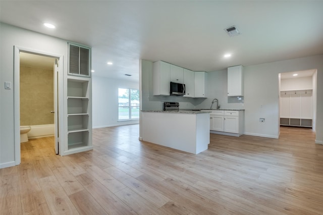 424 Stonewall Dr, Euless, TX 76039 - kitchen with appliances with stainless steel finishes, a sink, light wood-type flooring, white cabinets, and light stone countertops