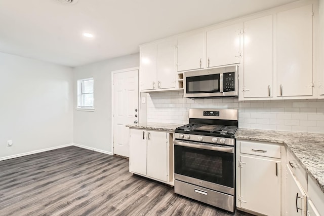 7805 Whitney Dr, White Settlement, TX 76108 - kitchen with appliances with stainless steel finishes, baseboards, dark wood-type flooring, white cabinetry, and tasteful backsplash