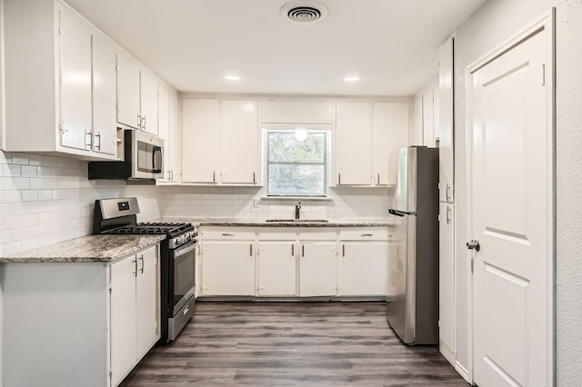 7805 Whitney Dr, White Settlement, TX 76108 - kitchen with appliances with stainless steel finishes, a sink, white cabinetry, backsplash, and recessed lighting
