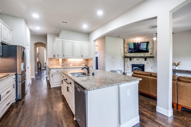 120 Crystal Creek Ln, Mckinney, TX 75071 - kitchen with stainless steel appliances, open floor plan, a sink, ceiling fan, and a stone fireplace