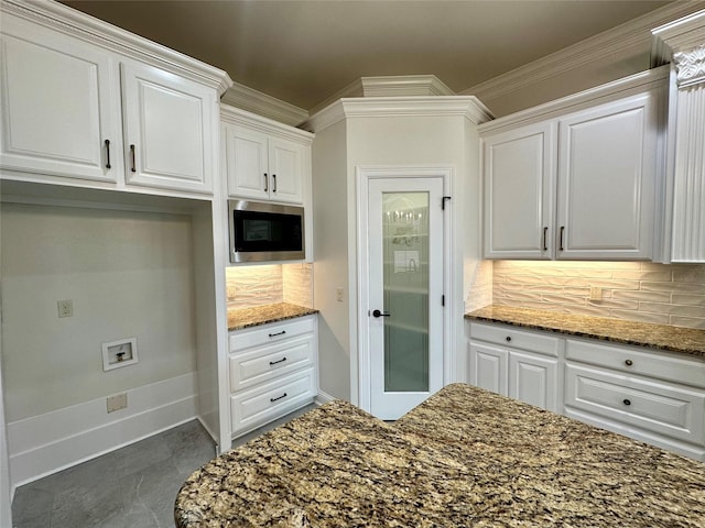 723 Dumaine Dr, Bossier City, LA 71111 - kitchen featuring stainless steel microwave, tasteful backsplash, dark stone counters, white cabinets, and crown molding