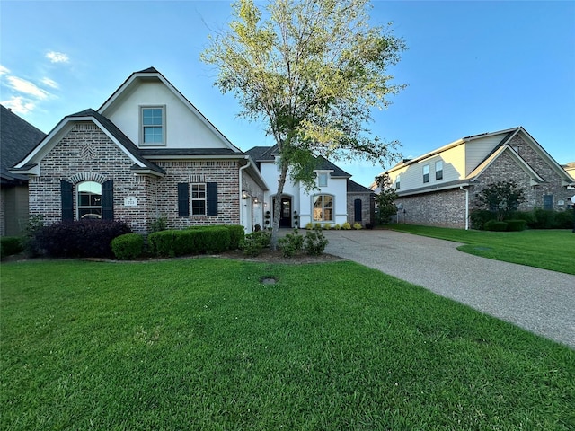 723 Dumaine Dr, Bossier City, LA 71111 - view of front of home featuring stucco siding, a front yard, brick siding, and driveway