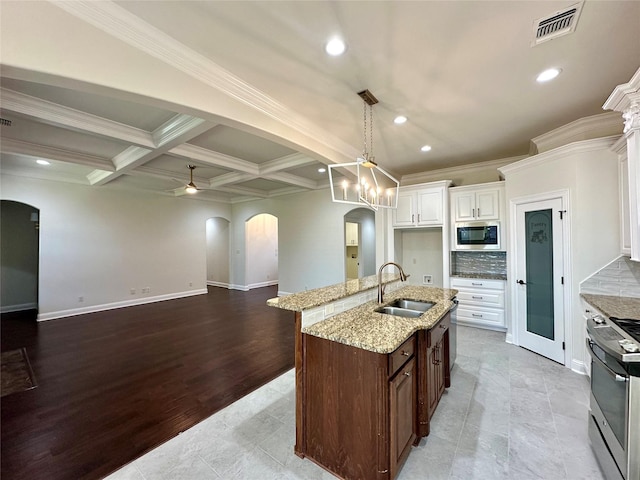 723 Dumaine Dr, Bossier City, LA 71111 - kitchen featuring arched walkways, stainless steel appliances, a sink, recessed lighting, and light stone countertops