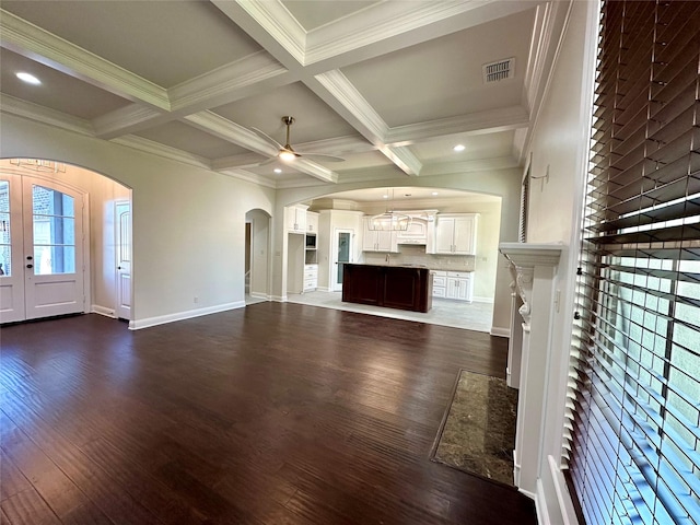 723 Dumaine Dr, Bossier City, LA 71111 - unfurnished living room with arched walkways, a ceiling fan, beam ceiling, ornamental molding, and dark wood-style flooring