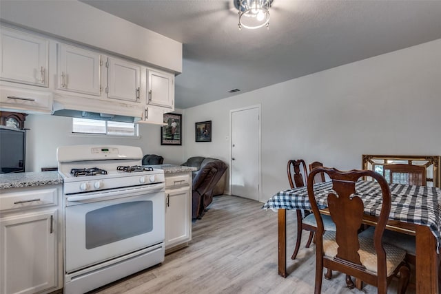 1859 Greendale Dr, Dallas, TX 75217 - kitchen with white range with gas stovetop, under cabinet range hood, light wood-style floors, and white cabinets
