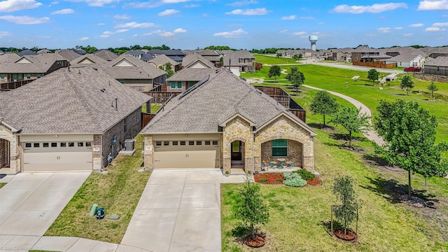 french provincial home featuring a residential view, driveway, a front lawn, and brick siding