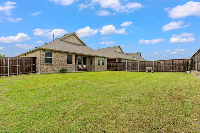 rear view of property with brick siding, roof with shingles, and a patio