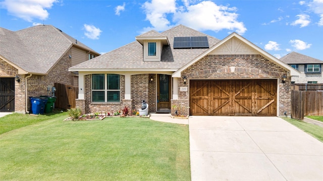 view of front facade with brick siding, a garage, a shingled roof, solar panels, and concrete driveway