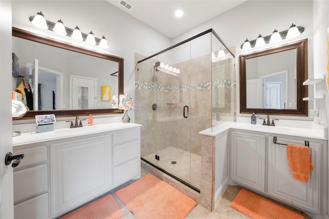 full bath with a shower stall and two vanities