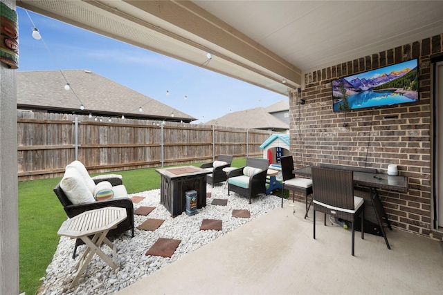 view of patio with fence and an outdoor living space with a fire pit