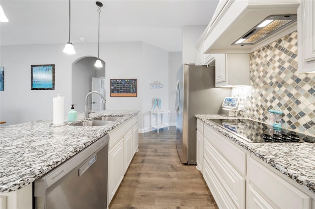 kitchen with stainless steel dishwasher, a sink, black electric cooktop, premium range hood, and light wood-style floors