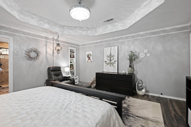 bedroom with wood finished floors, a raised ceiling, ornamental molding, and baseboards