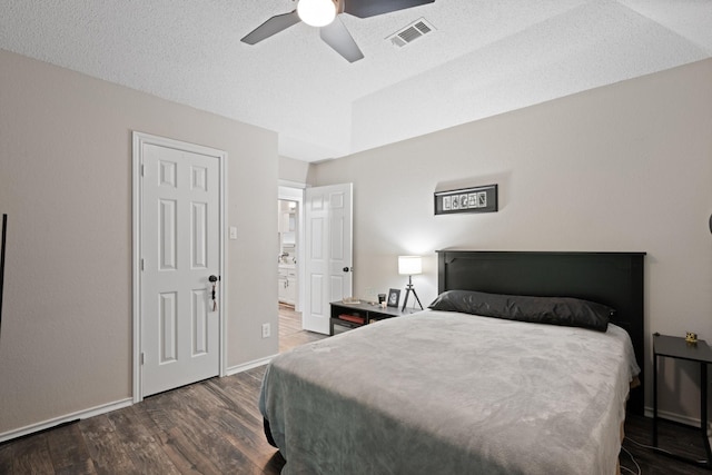 bedroom featuring wood finished floors, baseboards, ensuite bath, ceiling fan, and a textured ceiling