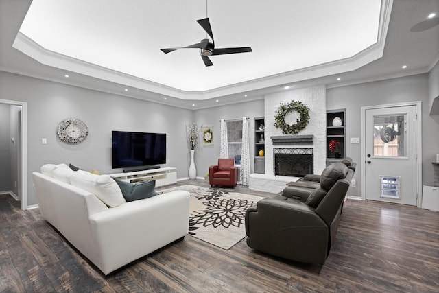 living room featuring a tray ceiling, ornamental molding, ceiling fan, recessed lighting, and baseboards