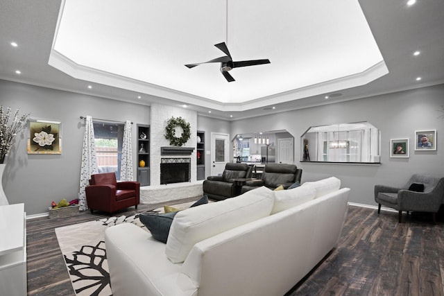 living room featuring a raised ceiling, recessed lighting, a ceiling fan, baseboards, and wood finished floors