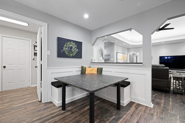 dining space featuring dark wood-style flooring, a wainscoted wall, recessed lighting, a decorative wall, and a textured ceiling