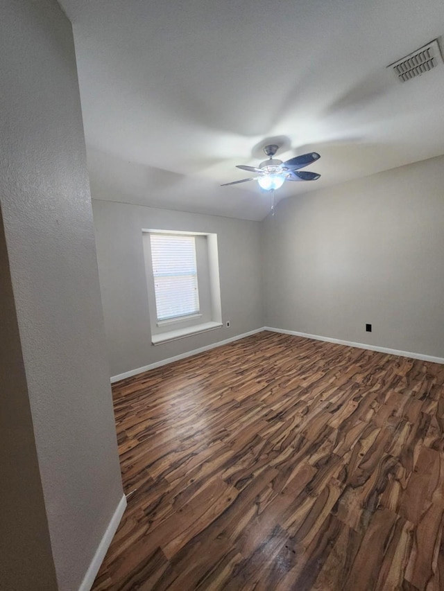 unfurnished room featuring dark wood finished floors, baseboards, and ceiling fan