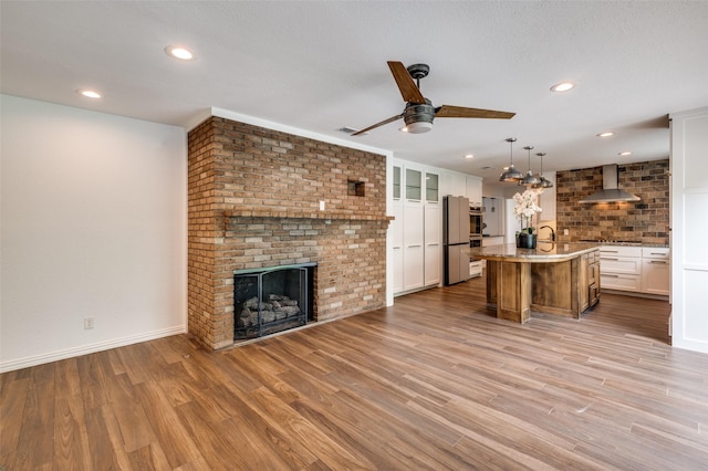 6740 Fortune Rd, Fort Worth, TX 76116 - unfurnished living room with a ceiling fan, light wood finished floors, a brick fireplace, recessed lighting, and baseboards