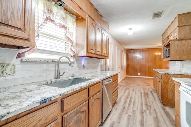 kitchen featuring a sink, stainless steel appliances, backsplash, light stone countertops, and a textured ceiling