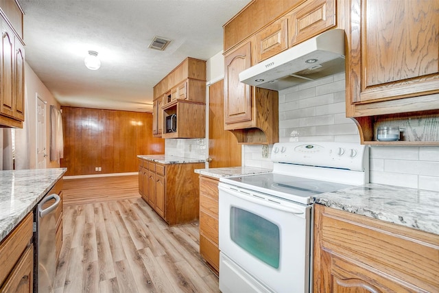 kitchen with white electric range oven, under cabinet range hood, light stone countertops, backsplash, and light wood-style flooring