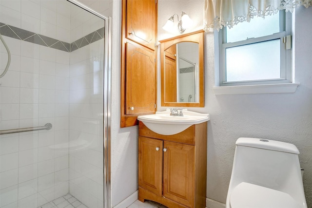 bathroom with a stall shower, toilet, and vanity