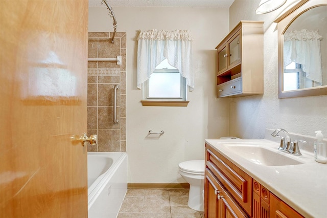 bathroom featuring tile patterned floors, vanity, toilet, baseboards, and shower / washtub combination