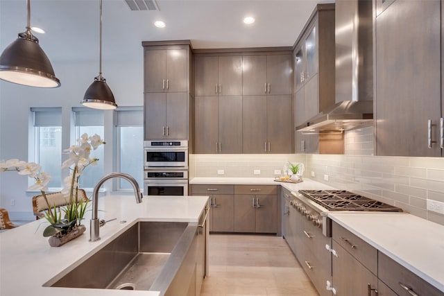 7704 Highcroft Way, Plano, TX 75024 - kitchen with wall chimney exhaust hood, a sink, appliances with stainless steel finishes, light countertops, and backsplash