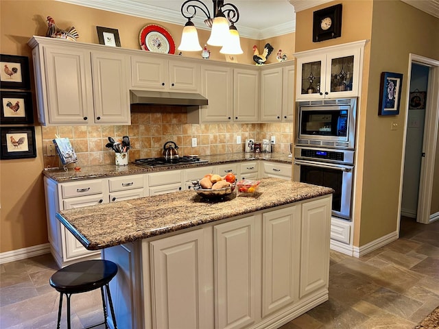 321 Fairway Meadows Dr, Garland, TX 75044 - kitchen with appliances with stainless steel finishes, under cabinet range hood, crown molding, white cabinets, and a chandelier