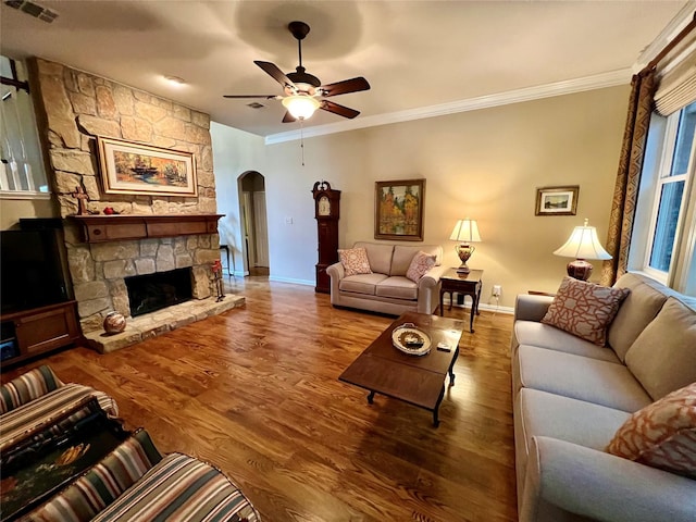 321 Fairway Meadows Dr, Garland, TX 75044 - living area with arched walkways, crown molding, a ceiling fan, wood finished floors, and a stone fireplace