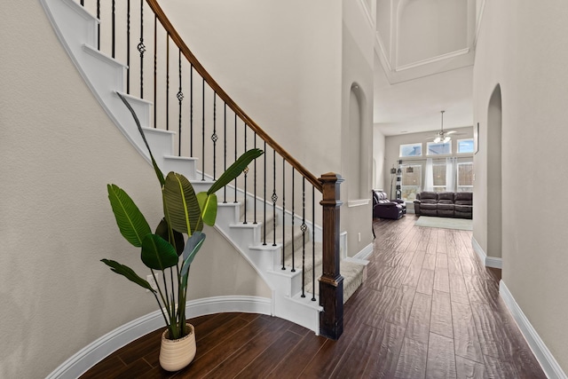 2444 Kingsgate Dr, Little Elm, TX 75068 - stairway featuring wood-type flooring, arched walkways, a high ceiling, and baseboards