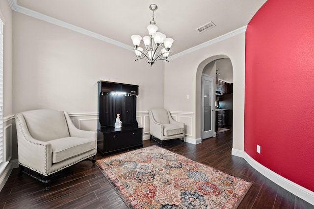 2444 Kingsgate Dr, Little Elm, TX 75068 - sitting room featuring arched walkways, crown molding, wood finished floors, a chandelier, and a wainscoted wall