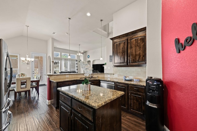 2444 Kingsgate Dr, Little Elm, TX 75068 - kitchen featuring appliances with stainless steel finishes, a chandelier, dark wood finished floors, a kitchen island, and backsplash