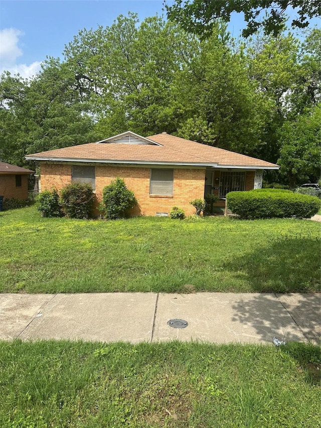 view of side of home featuring a lawn and brick siding