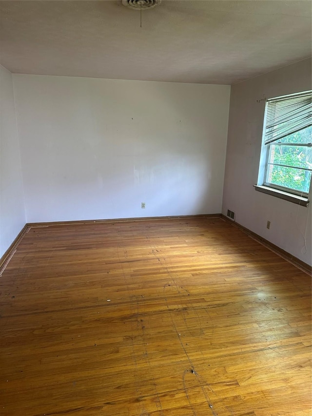 empty room with wood-type flooring and baseboards