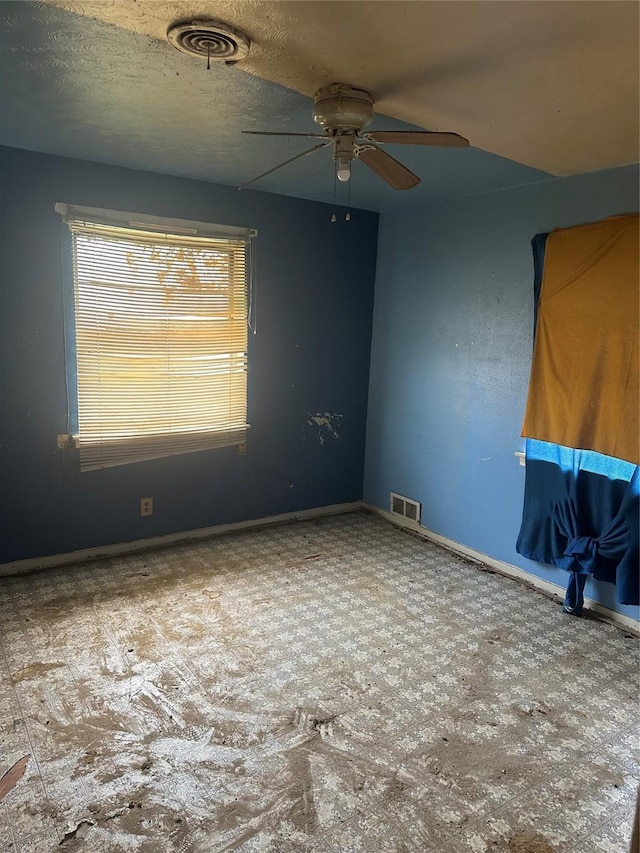 unfurnished room featuring ceiling fan and baseboards