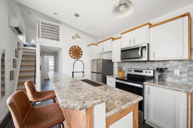 6444 Peninsula Rd, Kerens, TX 75144 - kitchen featuring appliances with stainless steel finishes, a wall mounted air conditioner, decorative backsplash, a breakfast bar area, and white cabinetry