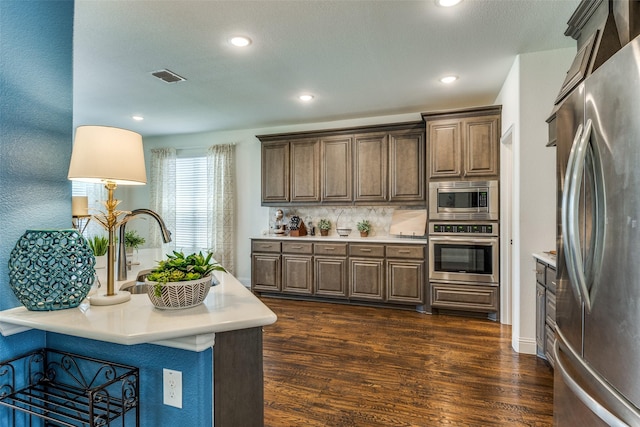 1839 Tuscany Dr, Mclendon Chisholm, TX 75032 - kitchen with appliances with stainless steel finishes, dark wood-style flooring, light countertops, decorative backsplash, and recessed lighting