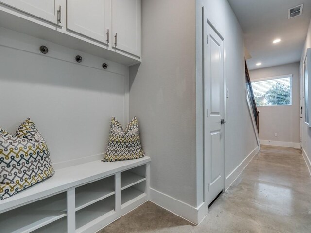 mudroom with baseboards, concrete flooring, and recessed lighting