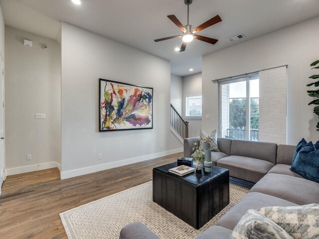 living area featuring wood finished floors, ceiling fan, stairway, recessed lighting, and baseboards