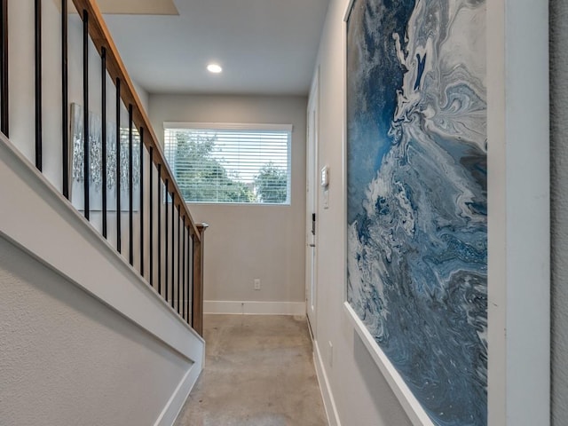 staircase with baseboards, concrete flooring, and recessed lighting