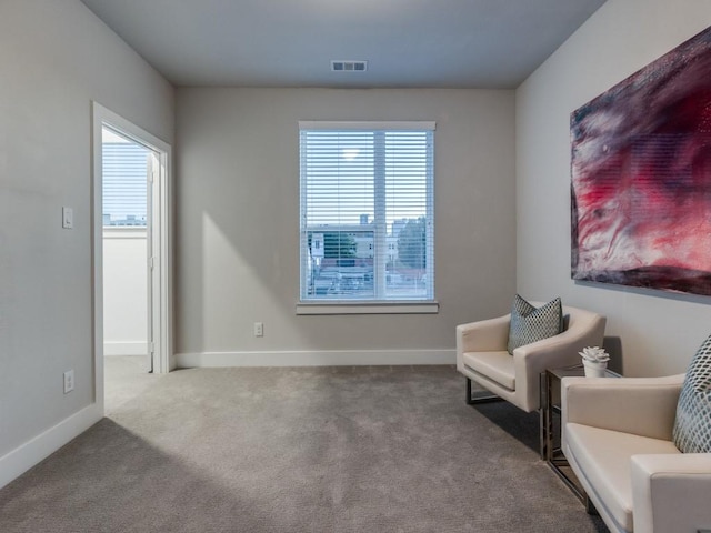 living area featuring plenty of natural light, carpet, and baseboards