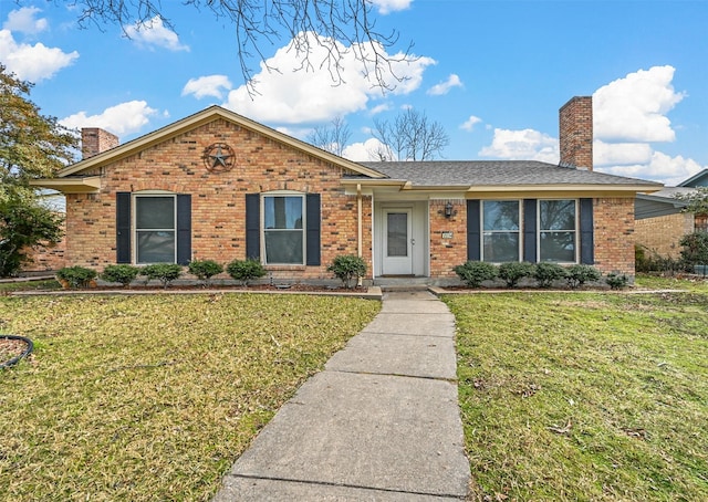 single story home featuring a chimney, brick siding, and a front lawn