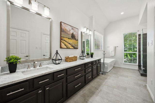 2805 Bitterroot Ct, Plano, TX 75025 - full bathroom featuring baseboards, a freestanding bath, double vanity, lofted ceiling, and recessed lighting