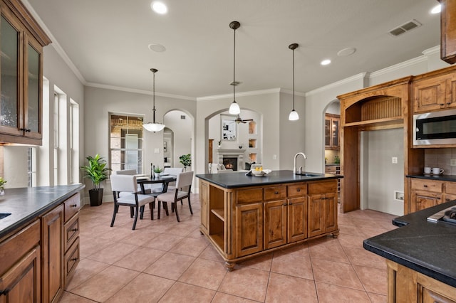 1665 Florence Rd, Keller, TX 76262 - kitchen with arched walkways, stainless steel microwave, dark countertops, a sink, and light tile patterned flooring