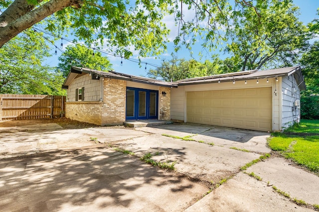 723 Westover Dr, Richardson, TX 75080 - view of front of home featuring brick siding, driveway, a garage, and french doors