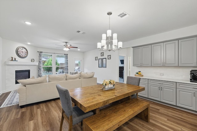 1837 Sebright Trl, Fort Worth, TX 76052 - dining room with recessed lighting, dark wood-style floors, ceiling fan, a chandelier, and a fireplace
