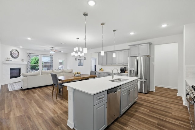 1837 Sebright Trl, Fort Worth, TX 76052 - kitchen featuring gray cabinets, a glass covered fireplace, stainless steel appliances, a sink, and light countertops